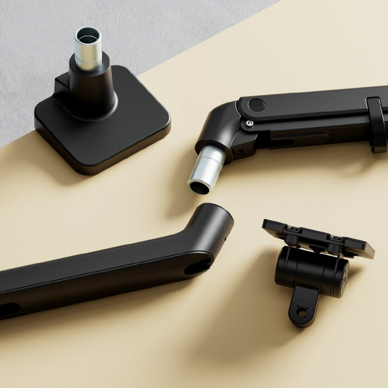 Close-up of monTEK black monitor arm components and joints displayed on a beige surface